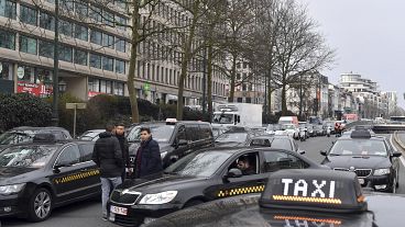 FILE: Taxi drivers use their vehicles to block roads on the inner ring of Brussels during a protest against general taxi regulations and Uber, Tuesday, March 27, 2018.