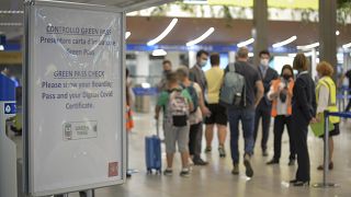 A sign indicates passengers to prepare their documents, including vaccination certificates, at Milan's Linate airport