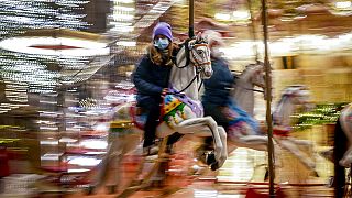 A girl rides on a merry-go-round on the first day of the Christmas market in Frankfurt, Germany, Monday, Nov. 22, 2021.