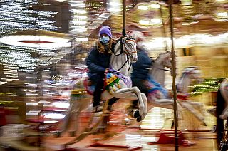 A girl rides on a merry-go-round on the first day of the Christmas market in Frankfurt, Germany, Monday, Nov. 22, 2021.