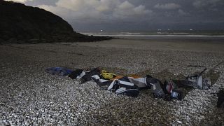 Life jackets, sleeping bags and damaged inflatable small boat are pictured on the shore in Wimereux, northern France, Friday, Nov. 26, 2021 in Calais, northern France.