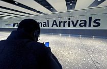 Un hombre consulta su teléfono móvil en la sección de llegadas del aeropuerto internacional de Heathrow, en Londres, el viernes 26 de noviembre de 2021.