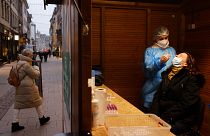 A woman has a transgenic test made at the Christmas market during its preparation in Strasbourg, eastern France, Nov. 25, 2021.