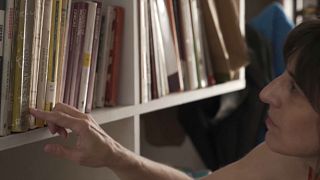 La escritora chilena Alejandra Costamagna busca un libro en una estantería