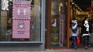 Signs warn shoppers of mandatory face mask and the need to respect social distancing in Nijmegen, eastern Netherlands, Sunday, Nov. 28, 2021.
