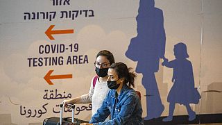 Des voyageurs portant des masques arrivent à l'aéroport Ben Gourion de Tel-Aviv en Israël, 28/11/2021