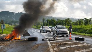 Vehicle passes close to the garbage burning on the ground on the French Caribbean island of Martinique.