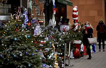 Egy nő nézelődik egy karácsonyi dekorációba öltöztetett mayfair-i borkereskedés előtt Londonban
