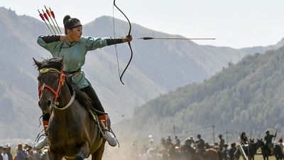 صورة لامرأة تطلق سهمًا خلال مسابقة للرماية في مدينة شولبون آتا، في قيرغيزستان