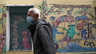 Ein älterer Mann läuft durch die Straßen von Athen mit einer Maske. In Griechenland werden derzeit mehr und mehr COVID-19-Todesfälle gemeldet.