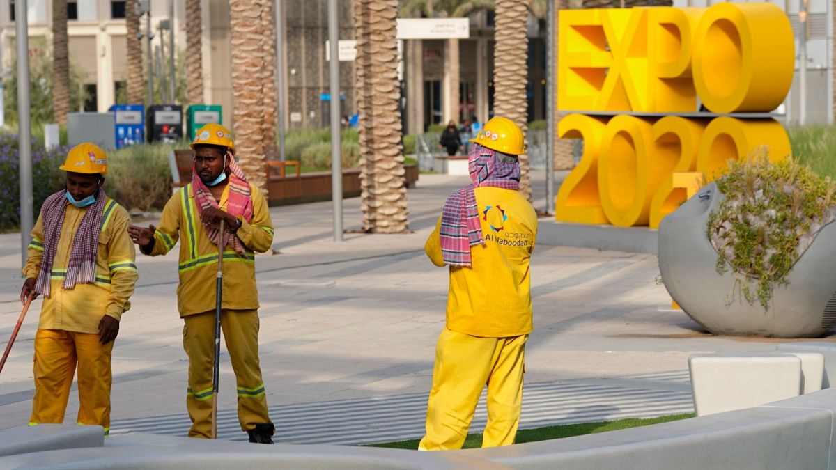 عمال ينظفون منطقة بمعرض إكسبو 2020 في دبي