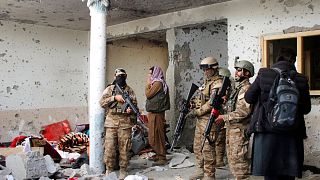 Taliban fighters inspect a house after an 8-hour gunbattle