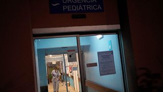 A worker wipes the floor by the pediatric emergency entrance at the Hospital Garcia de Orta in Almada, south of Lisbon, Tuesday, Nov. 30, 2021.