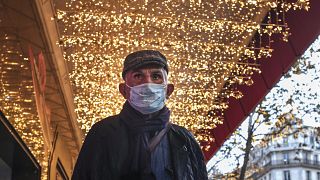Homme masqué dans les rues de Paris, illuminées pour Noël, France, 30 novembre 2021
