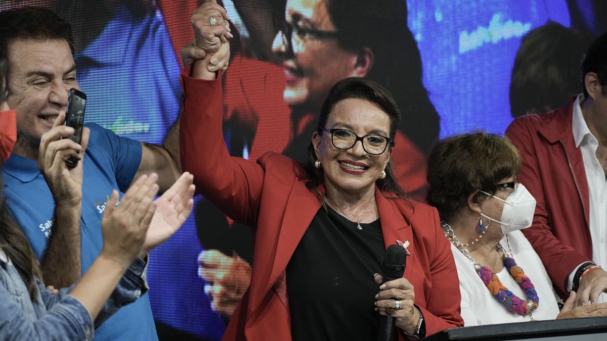 Free Party presidential candidate Xiomara Castro has her hand raised by her running mate Salvador Nasralla after general elections, in Tegucigalpa, Honduras.