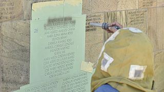 15 novembre 2021: l'incisore Randy Montgomery aggiunge nuovi nomi al Wall Las Memorias AIDS Monument a Lincoln Park, Los Angeles