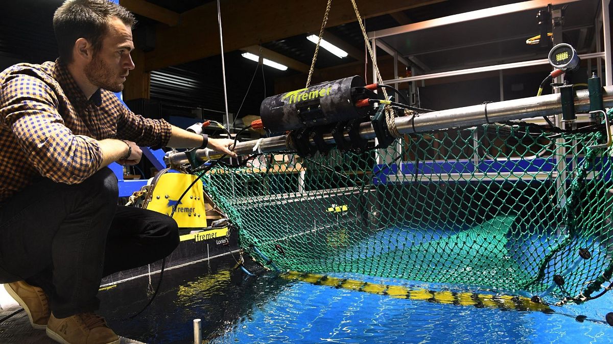 French Ifremer engineer Julien Simon tests a fishing net equiped with a camera to sort fish species on October 5, 2021.