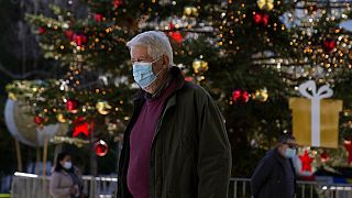 Férfi sétál az athéni Syntagma téren felállított karácsonyfa előtt Görögországban, 2021 december 1-én