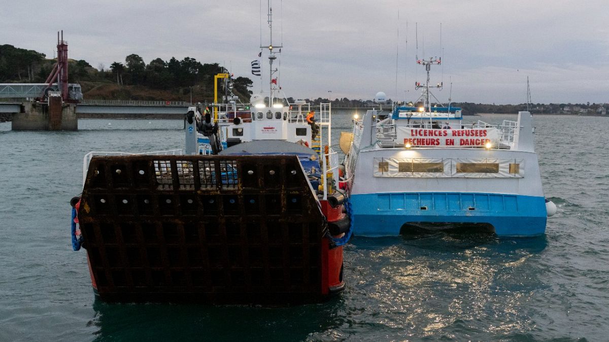 French fishing boats with Normandy Trader at left block the entrance to the port of Saint-Malo, western France, Friday, Nov. 26, 2021. 