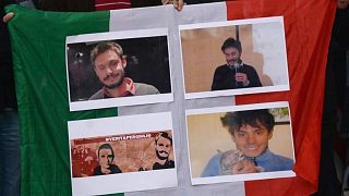 People hold an Italian flag with photos of Giulio Regeni during a 2016 demonstration in front of Egypt's embassy in Rome.