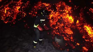 Un miembro de la Unidad Militar de Emergencia recoge muestras de lava en la isla española de La Palma