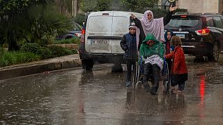 لاجئة سورية وأطفالها أثناء هطول الأمطار الغزيرة في بيروت، لبنان.