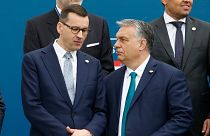 Poland's Prime Minister Mateusz Morawiecki, left, and Hungary's Prime Minister Victor Orban share a word as they line up for a group picture prior to a meeting in Beja, Portug