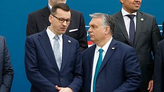 Poland's Prime Minister Mateusz Morawiecki, left, and Hungary's Prime Minister Victor Orban share a word as they line up for a group picture prior to a meeting in Beja, Portug