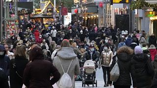 People wear mandatory face masks in a shopping street in Dortmund, Germany, Dec. 1, 2021