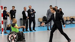 Le président français Emmanuel Macron avec un membre de l'équipe de handball handisport, à Créteil (près de Paris), le 09/01/2019