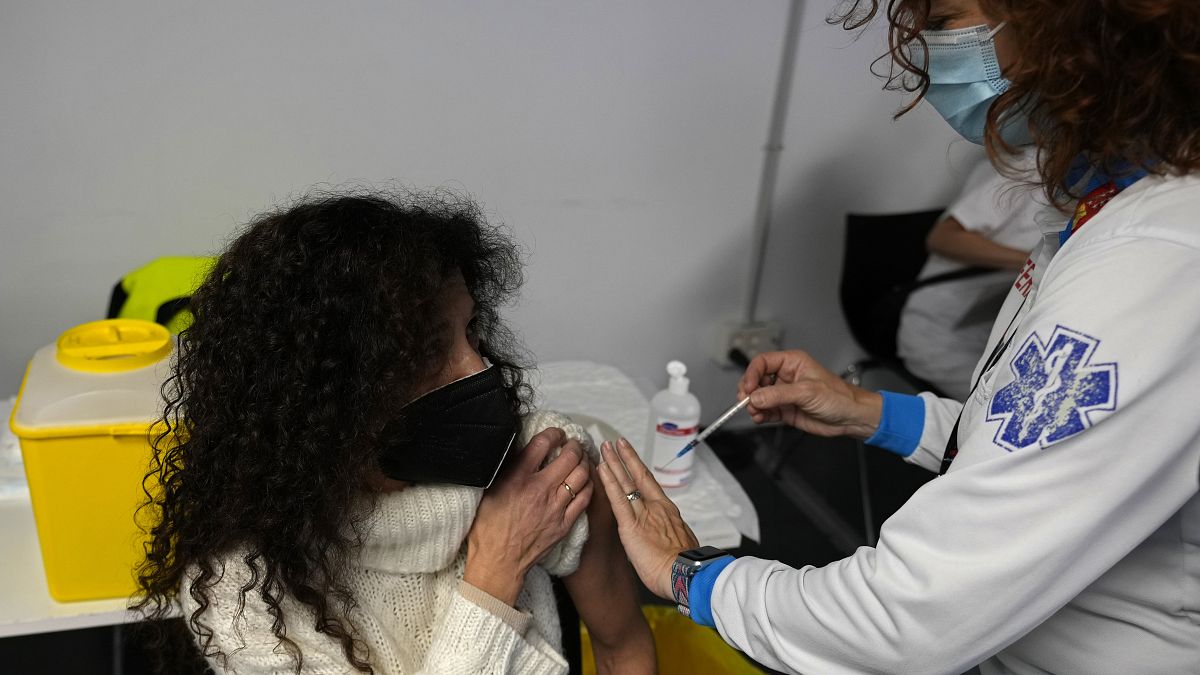 A woman receives a Pfizer COVID-19 vaccination in the Wizink Center in Madrid, Spain, Wednesday, Dec. 1, 2021.