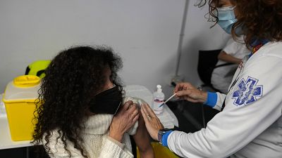A woman receives a Pfizer COVID-19 vaccination in the Wizink Center in Madrid, Spain, Wednesday, Dec. 1, 2021.
