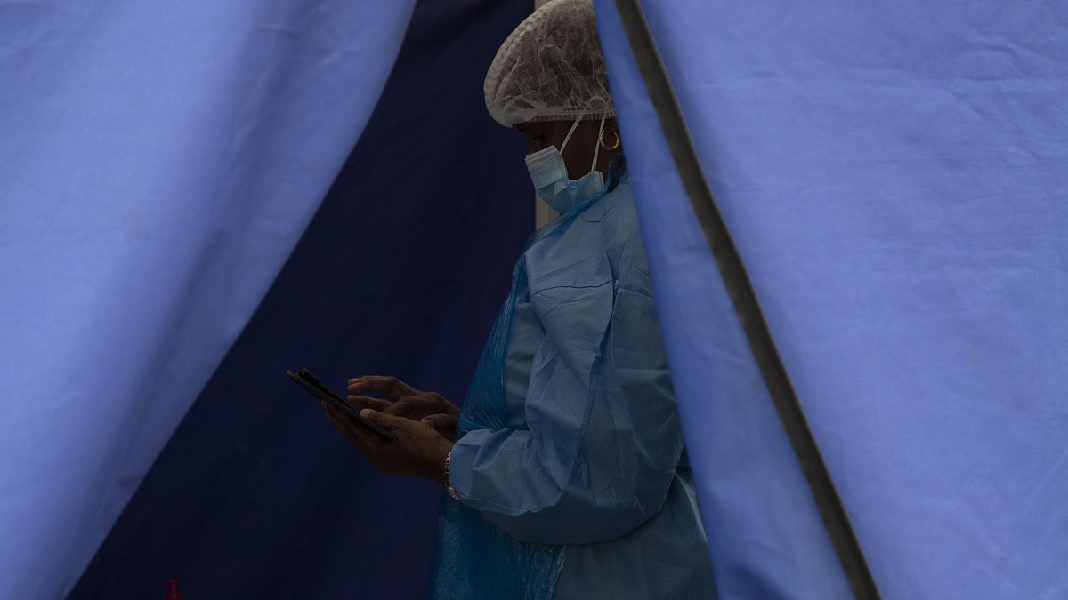 A healthcare worker waits to test people for 'COVID-19 at a facility in Soweto, South Africa, Wednesday Dec. 2, 2021. 