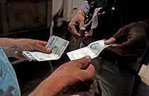 A Syrian man pays with Turkish lira at a gas station in the town of Sarmada in Syria's northwestern Idlib province, on June 15, 2020.