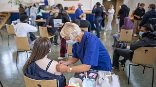 A student at Holtet high school receives the first dose of Pfizer vaccine against COVID-19 in the school's auditorium in Oslo, Sept. 7, 2021.