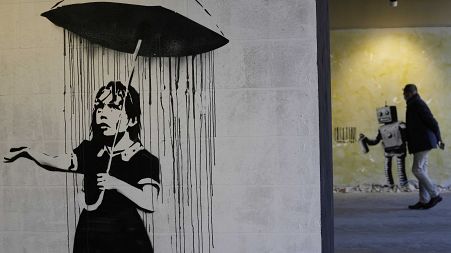 "The Umbrella girl" a reproduction of a mural by British artist Banksy is seen at an exhibition at the Milano Centrale main railway station in Milan, on Dec. 2, 2021.