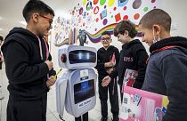 Palestinian students interact with a locally-made educational robot during a science class at a private school in Gaza City