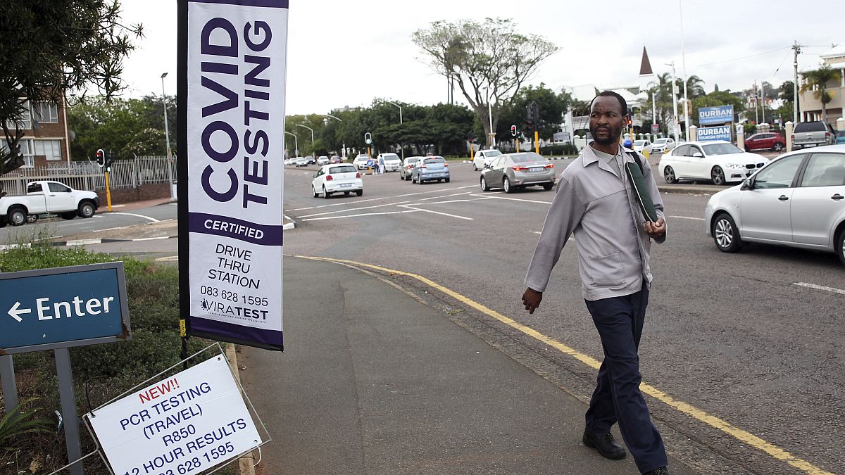 A man walks past a mobile COVID-19 testing station in Durban, South Africa, Friday, Dec. 3 2021. The new omicron variant appears to be driving a dramatic surge in the country.