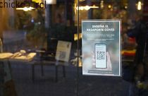 Un cartel solicitando el pasaporte covid está pegado en la puerta de un restaurante en Barcelona