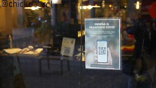 Un cartel solicitando el pasaporte covid está pegado en la puerta de un restaurante en Barcelona