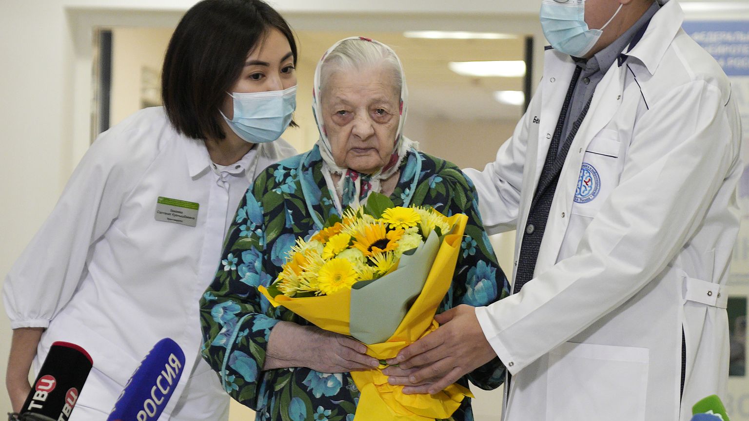 Doctors greet 101-year-old patient Pelageya Poyarkova with flowers as she leaves a COVID recovery ward, Federal Center for Brain and Neurotechnology, Moscow, Dec. 3, 2021.