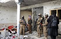 FILE: Taliban fighters inspect a house after an 8-hour gunbattle erupted between Taliban and IS group fighters near Jalalabad, Afghanistan, Tuesday, Nov. 30, 2021.