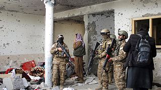 FILE: Taliban fighters inspect a house after an 8-hour gunbattle erupted between Taliban and IS group fighters near Jalalabad, Afghanistan, Tuesday, Nov. 30, 2021.