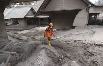 Un rescatista camina en una zona afectada por la erupción del volcán Semeru en el distrito de Lumajang, provincia de Java Oriental, Indonesia, el 5 de diciembre de 2021.