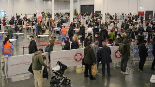 People wait in lines to register for COVID-19 vaccination  in Vienna, Austria