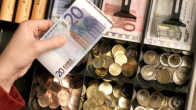 FILE - Euro coins and banknotes are pictured in a shop in Duisburg, Germany, Saturday, Dec. 29, 2001. 