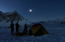 In this photo provided by Imagen de Chile, people view a total solar eclipse from Polar Union Glacier Camp in Antarctica