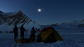 In this photo provided by Imagen de Chile, people view a total solar eclipse from Polar Union Glacier Camp in Antarctica