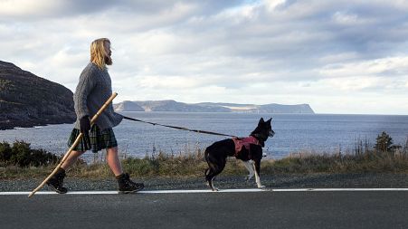 Michael Yellowlees, of Scotland, and his husky Luna walk the road to Cape Spear in Newfoundland and Labrador on Sunday, Dec. 5, 2021.