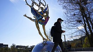 A visitor to the Shougang Park walks past the a sculpture for the Beijing Winter Olympics in Beijing, China, Tuesday, Nov. 9, 2021.